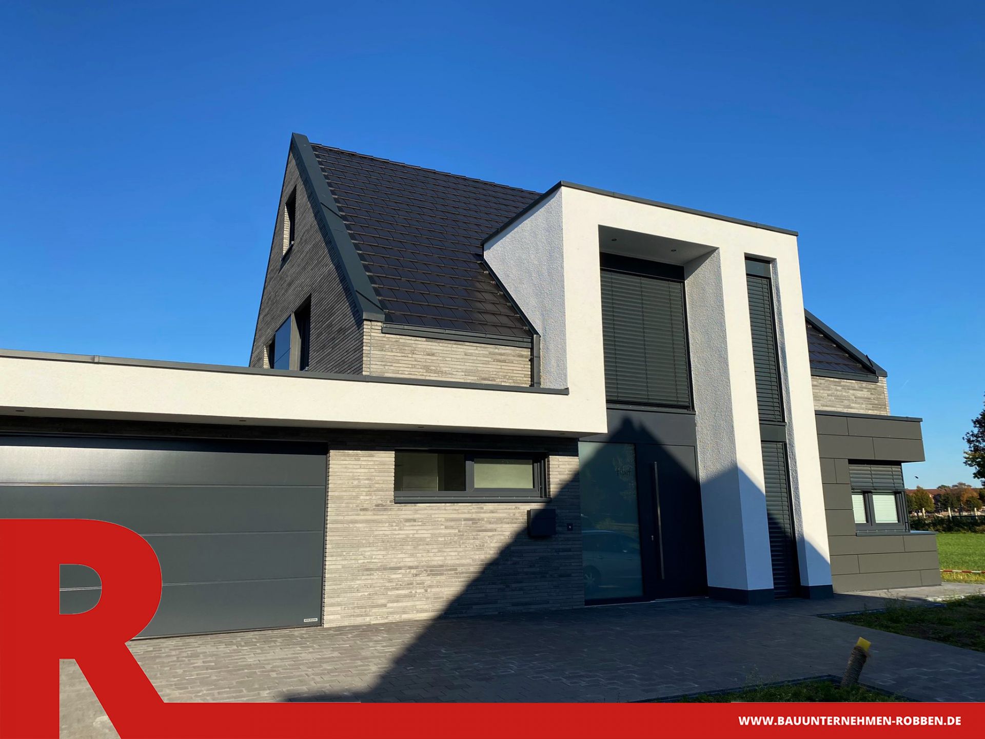 Einfamilienhaus mit einer Garage und Fassaden aus Stein, Holz, Putz und Fassadenplatten.