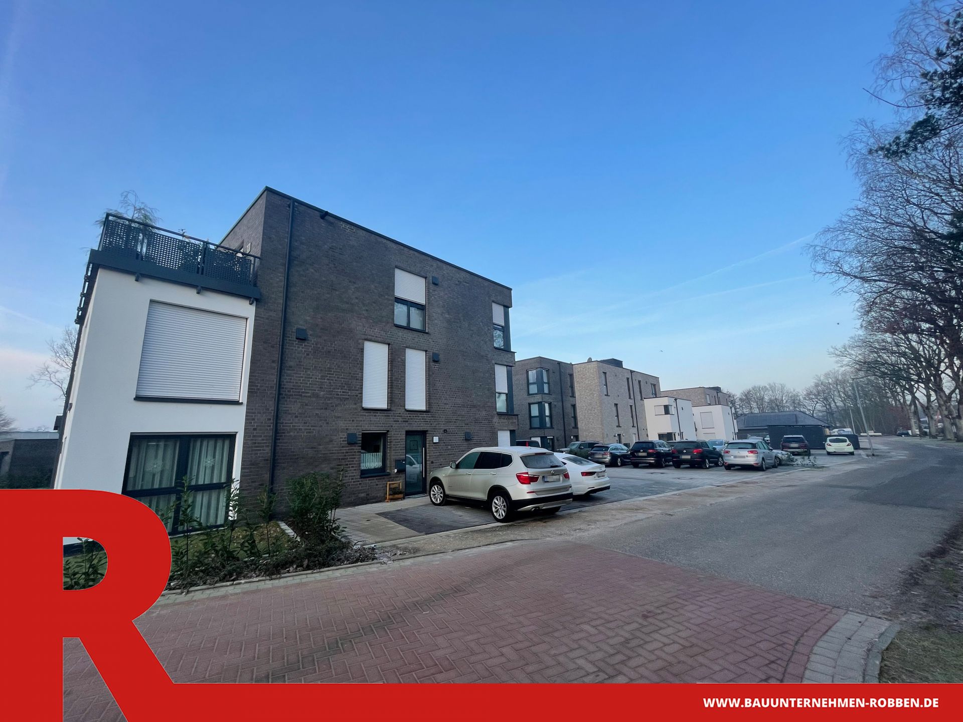 3 Mehrparteien-Häuser in Haselünne 3 Mehrparteienhäuser mit verschiedenfarbigen Klinkern und weißem Putz sowie Parkplätzen.