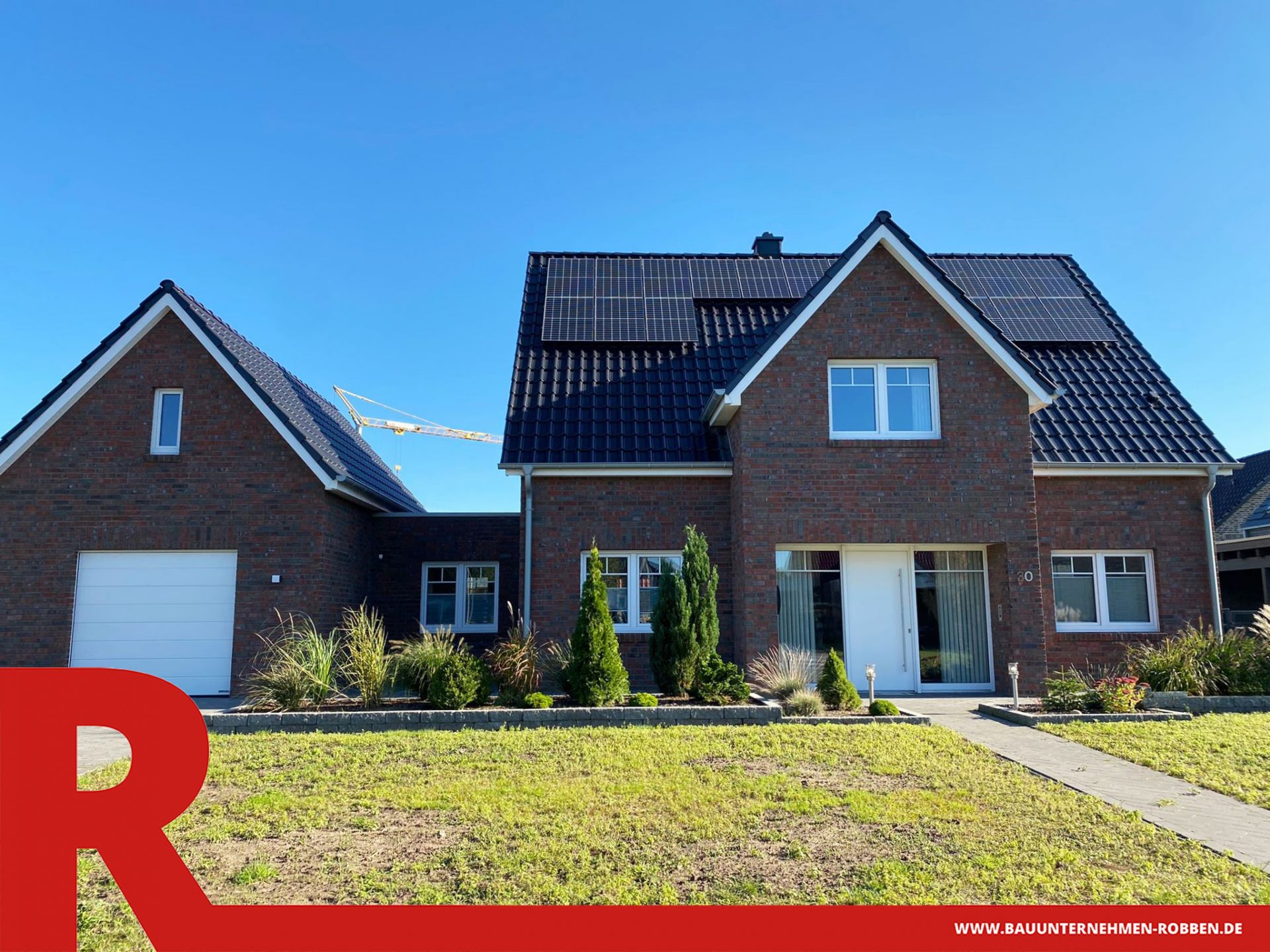 Einfamilienhaus mit einer Garage und einem Anbau zwischen der Garage und dem Haus.