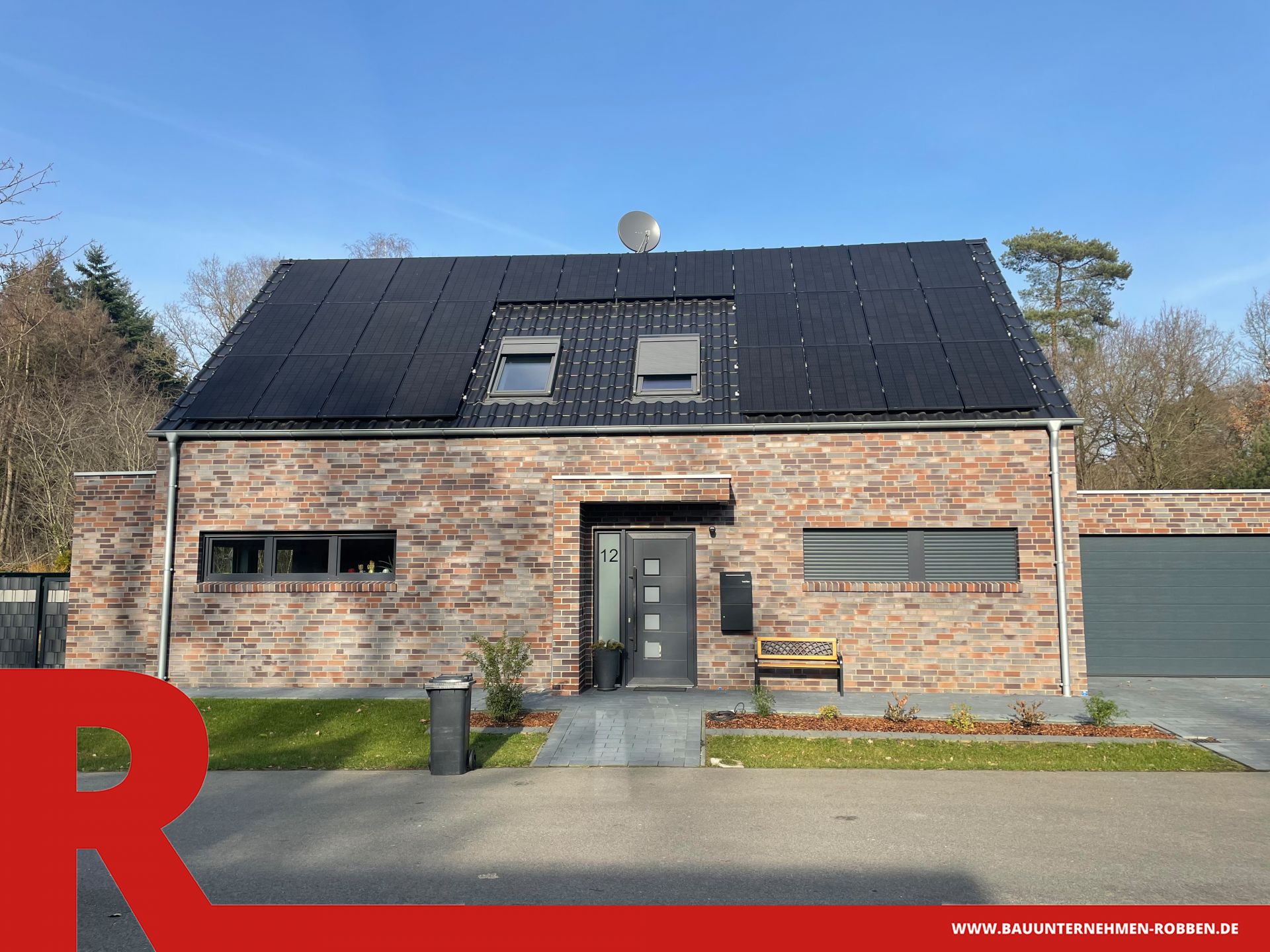 Einfamilienhaus in Meppen 1 Einfamilienhaus mit hellrotem Klinker, blauen Dachziegeln, Doppelgarage und PV-Anlagen.