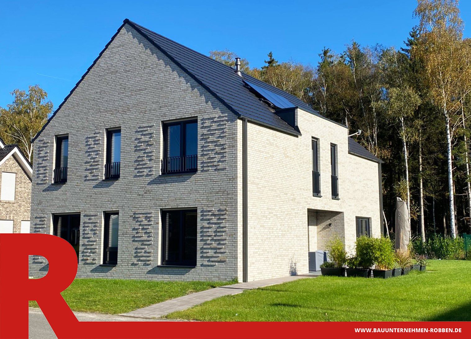 Architektenhaus mit weißen Klinkern und eingebautem Ziermauerwerk.