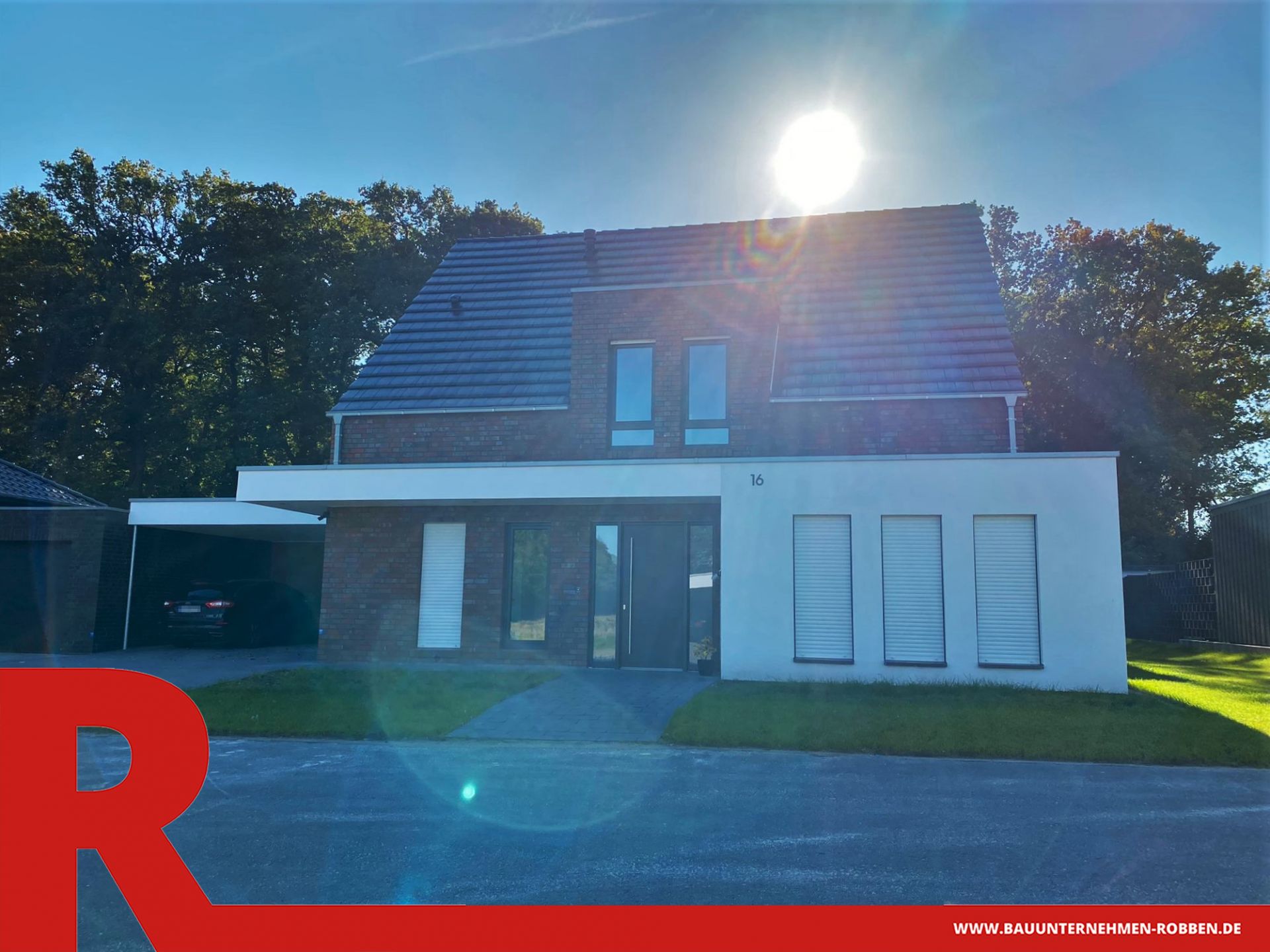 Einfamilienhaus mit einem Carport und einem Vorbau sowie Anbau aus weißem Putz.