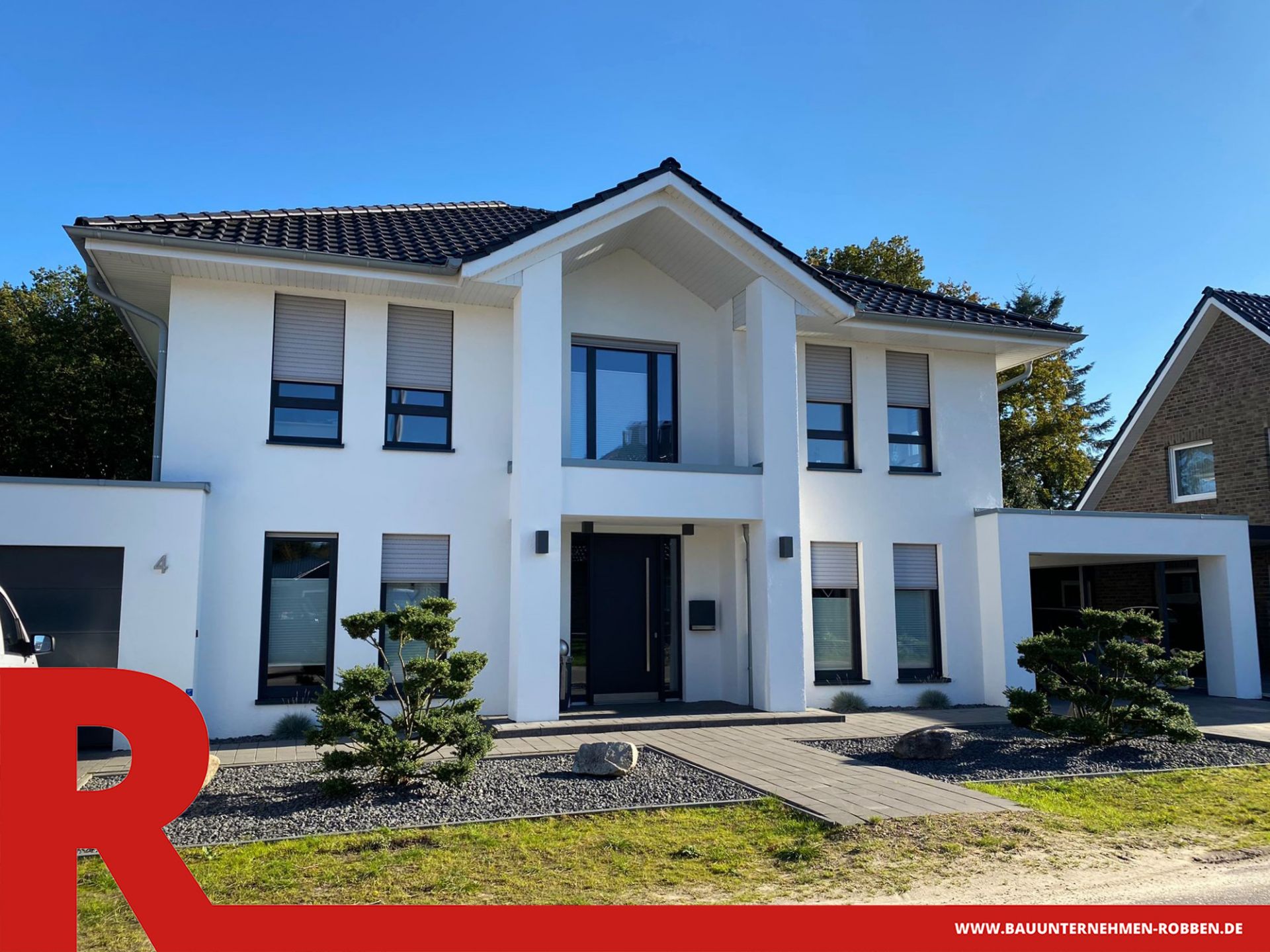 Modernes Einfamilienhaus in Stadtvilla-Optik mit weißen Fassaden, einer Garage und einem Carport.