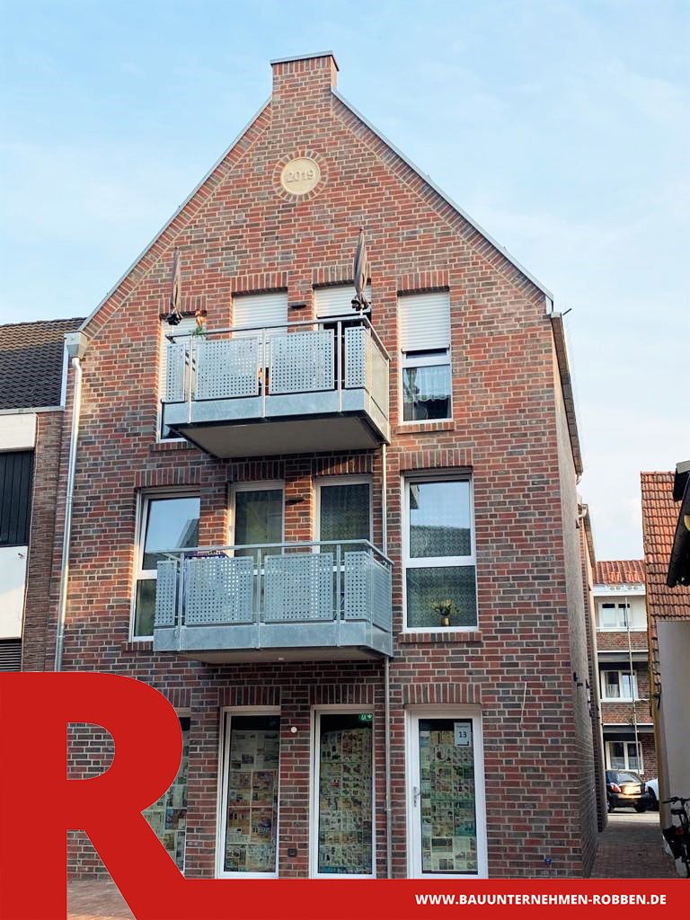 Stadthaus mit Wohnräumen über einer Gewerbeeinrichtung mit Außenfassade aus rotem Klinker.