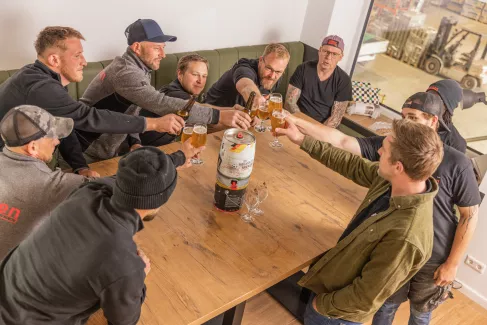 Zehn Mitarbeiter stoßen im Aufenthaltsraum der Mitarbeiter an.