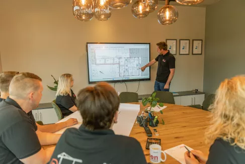 Bauzeichnung auf einem Smartboard an der Nico Robben den Mitarbeitern etwas erklärt.