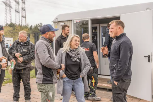 Mehrere Mitarbeiter stehen an Robben's Raste und unterhalten sich.