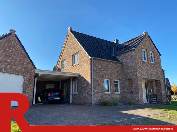 Einfamilienhaus in Haren Einfamilienhaus im Landhausstil mit Ziermauerwerk, einem Carport und einer Garage.