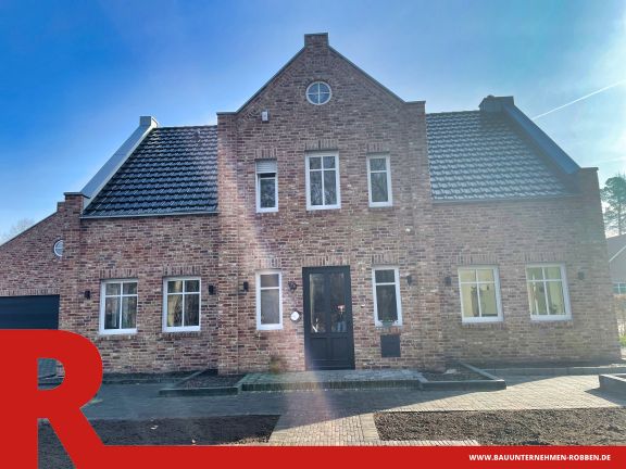 Einfamilienhaus in Schwefingen 3 Einfamilienhaus im Landhaus-Stil mit hellroten Ziegelsteinen und blauen Dachziegeln und Garage.