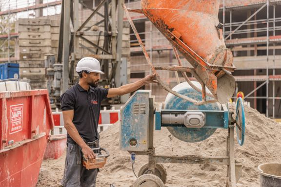 Impression_14 Ein Maurer richtet ein Gerät aus, um Beton zu verteilen.