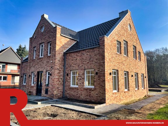 Einfamilienhaus in Schwefingen 1 Einfamilienhaus im Landhaus-Stil mit hellroten Ziegelsteinen und blauen Dachziegeln.