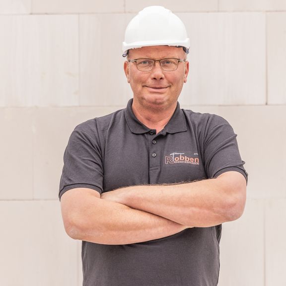 Foto des Poliers Michael Lammers vor einer Rohbau-Wand.