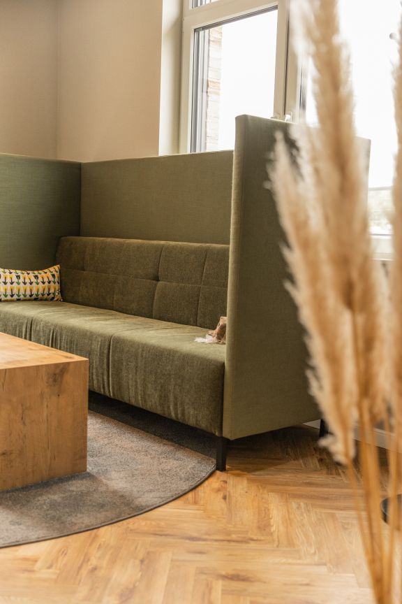 Wartebereich im B&uuml;rogeb&auml;ude mit Sofa.