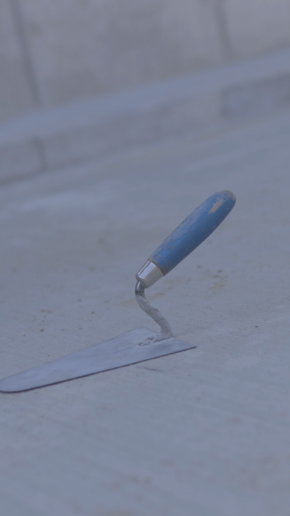 Vorschaubild_Kelle Bild einer Maurerkelle auf einem Betonboden.