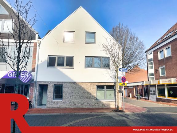 Gesch&auml;ftshaus mit hellen Ziegelsteinen und wei&szlig;em Putz in einer Innenstadt in Meppen.