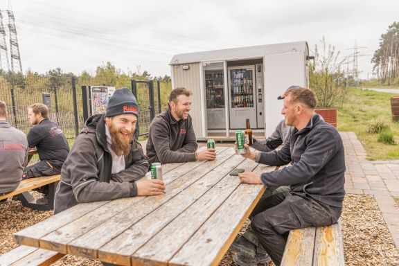 Vier Mitarbeiter sitzen auf einer Bank an Robben's Raste.