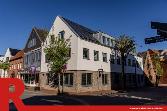 Geschäftshaus mit hellen Ziegelsteinen und weißem Putz in einer Innenstadt in Meppen.