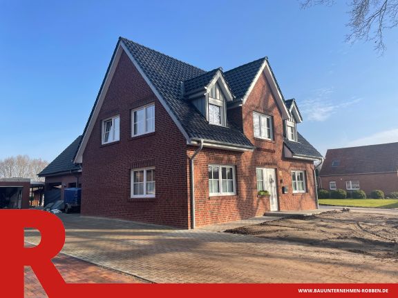 Einfamilienhaus in Twist 1 Das Bild zeigt ein Einfamilienhaus im Landhaus-Stil mit Ziermauerwerk an der Fassade.