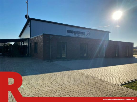 Bürogebäude der Firma Wocken Eine Halle der Firma Wocken mit Bürogebäude davor aus roten Klinkern und mit großen Fenstern.